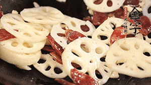 依次下香腸片、藕片翻炒均勻，加適量清水燜熟。