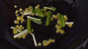 鍋中熱油，依次下姜粒、蔥段、蘆筍炒香。