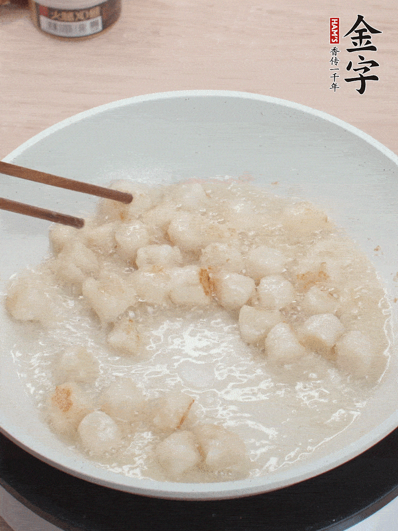 油溫4成熱，鮮貝蘸干淀粉下鍋煎，一面微黃后翻面。