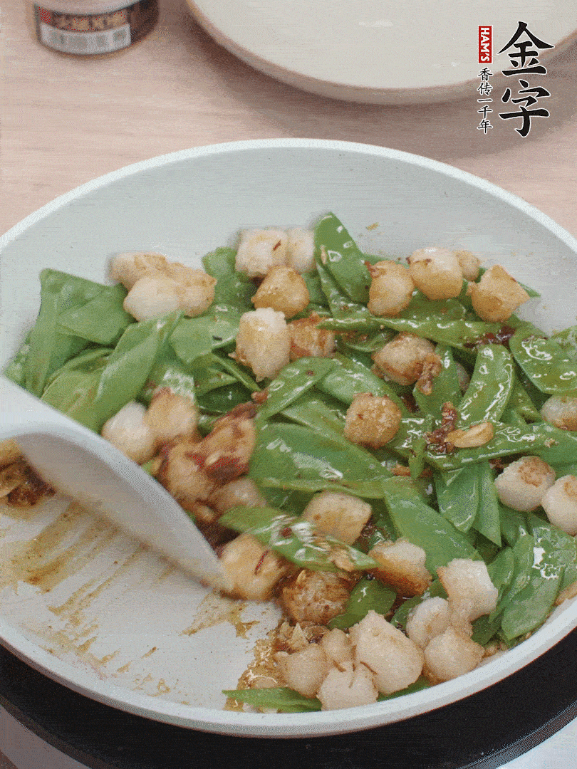 下甜豆莢、鮮貝輕輕翻炒均勻。