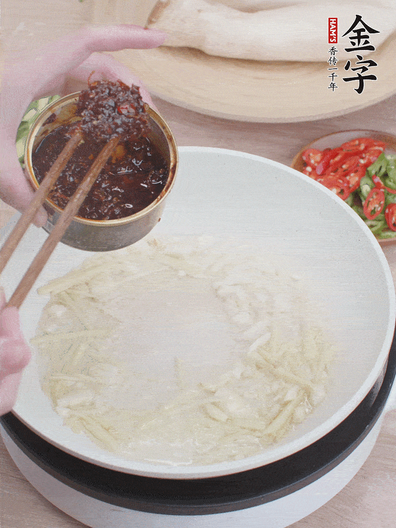 起鍋熱油，姜蒜、金字火腿干貝醬煸香。