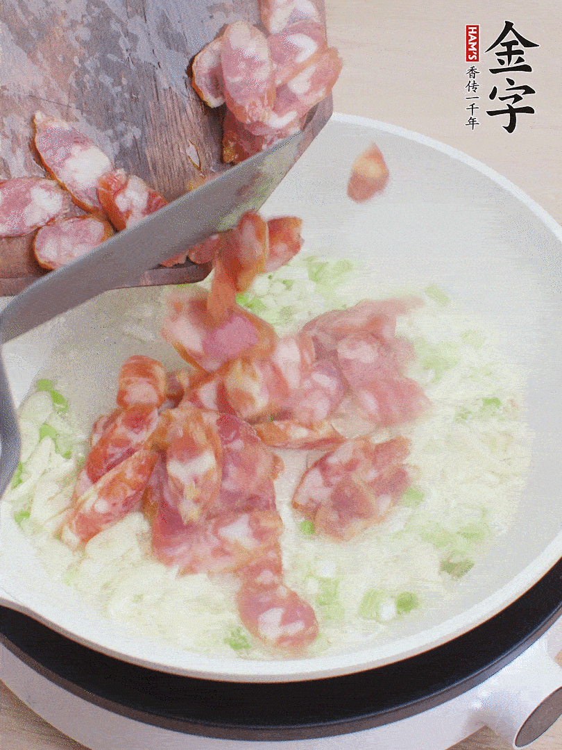 油5成熱，蒜末、蔥白爆香，下香腸炒出香味。