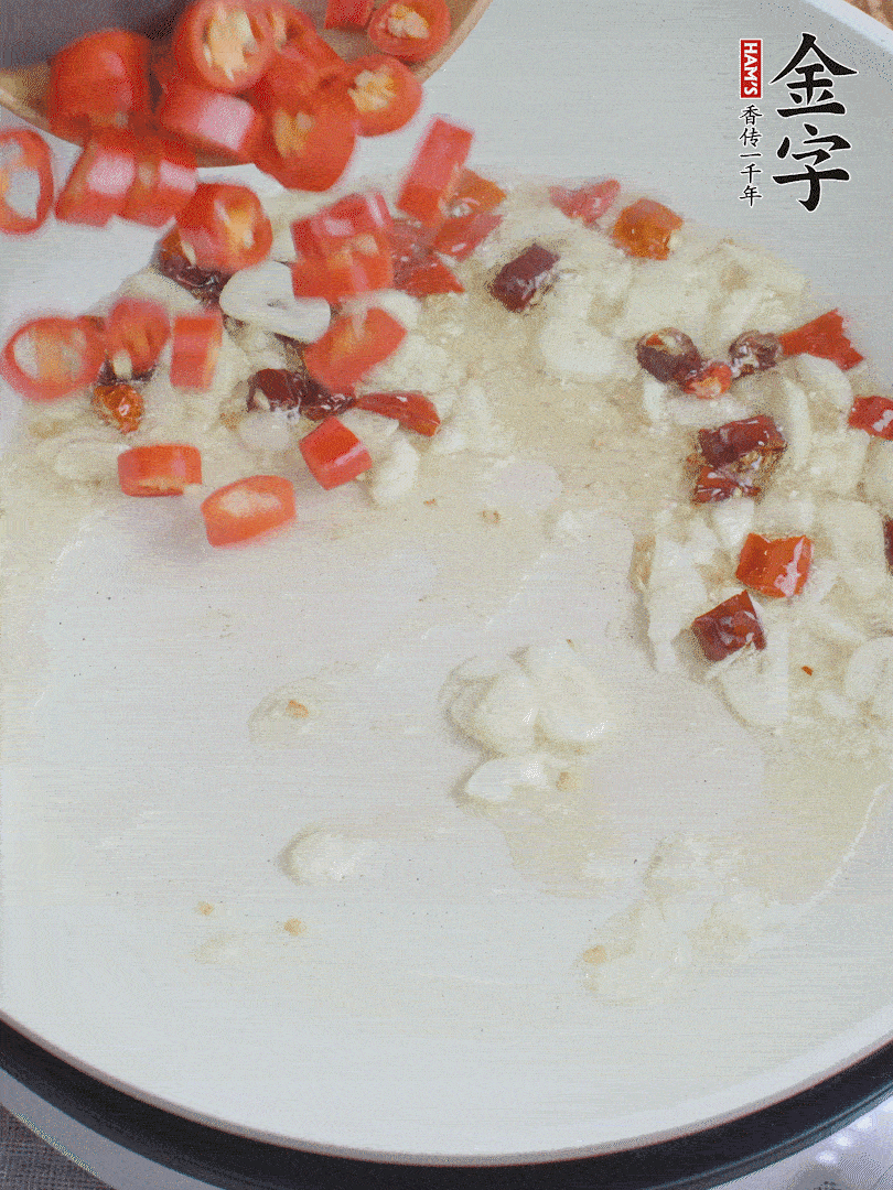 油6成熱，下蒜末、干紅辣椒煸炒，出香味后再放美人椒、香腸。