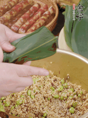 粽葉往下折，完全蓋住，兩側(cè)捏緊。