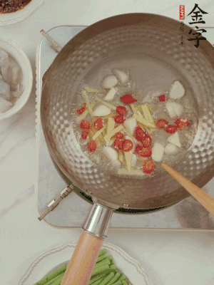 油7成熱時(shí)，下大蒜粒、姜絲、小米辣煸香。