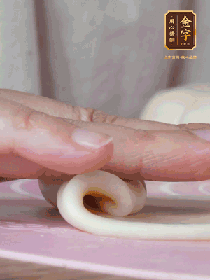 做面劑 油皮按扁，中間包入一個油酥，邊緣收緊捏死。包好的面劑按扁，用搟面杖搟壓成橢圓形。從底部向上卷成筒狀，用保鮮膜蓋好松弛15分鐘，再把筒狀縱向搟壓成長條狀。再卷一次，松弛20分鐘