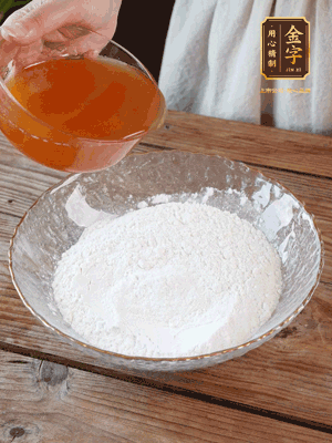 轉(zhuǎn)化糖漿、枧水、花生油攪拌均勻，加入面粉混合，醒發(fā)2小時。捏成23g一個的小球