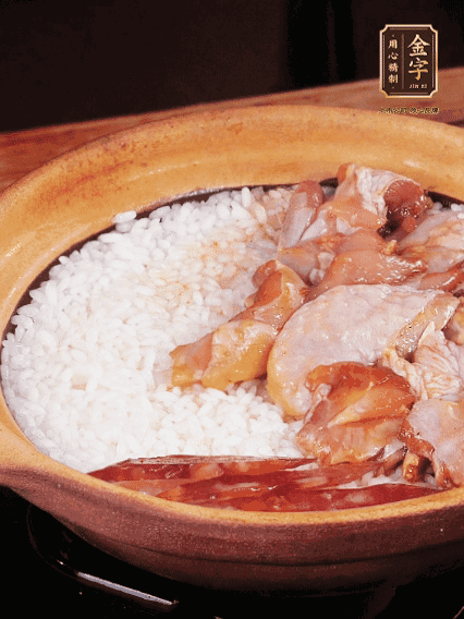 煮到椰子水微微收干轉(zhuǎn)小火，快速均勻鋪上雞肉、金字香腸