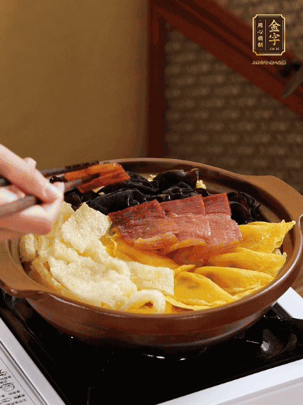 砂鍋底部鋪上娃娃菜，依次擺上肉皮、蛋餃、黑木耳、火腿